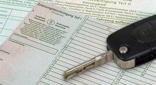 Zulassungsbescheinigung Teil 1 mit einem Autoschlüssel